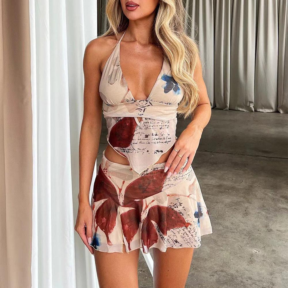 Woman wearing a red and white jacquard mini dress with floral patterns and side cutouts, posing on pink stairs in a summer setting.