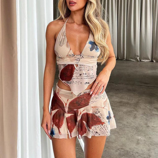 Woman wearing a red and white jacquard mini dress with floral patterns and side cutouts, posing on pink stairs in a summer setting.