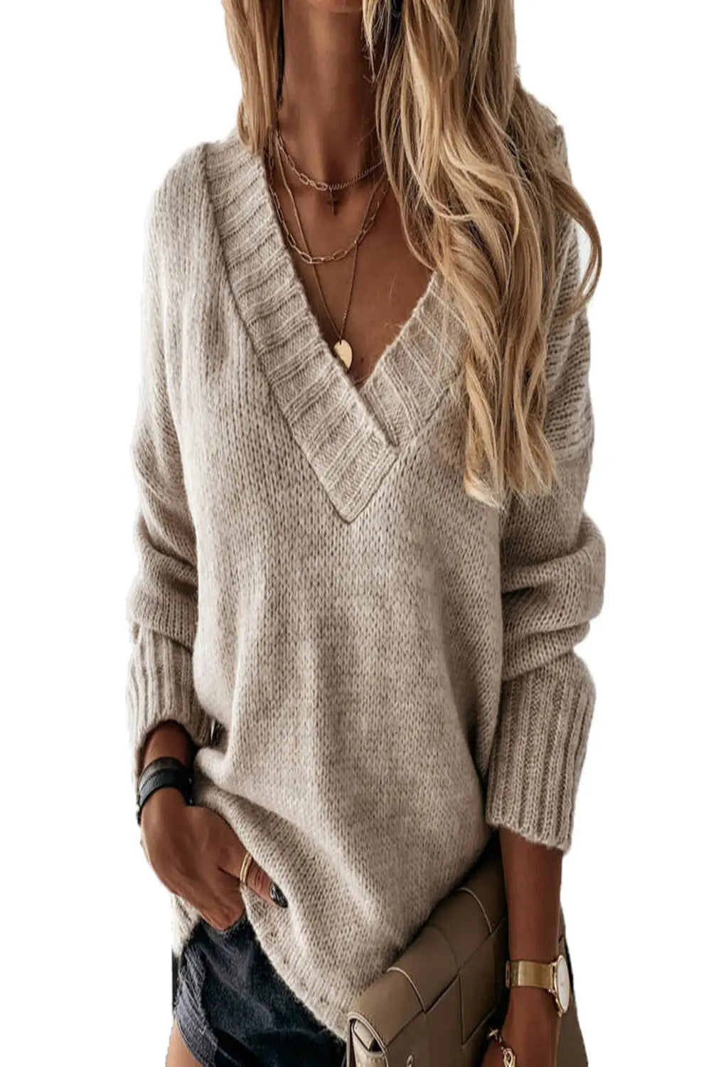 Woman wearing a black V-neck knit sweater with fitted black jeans